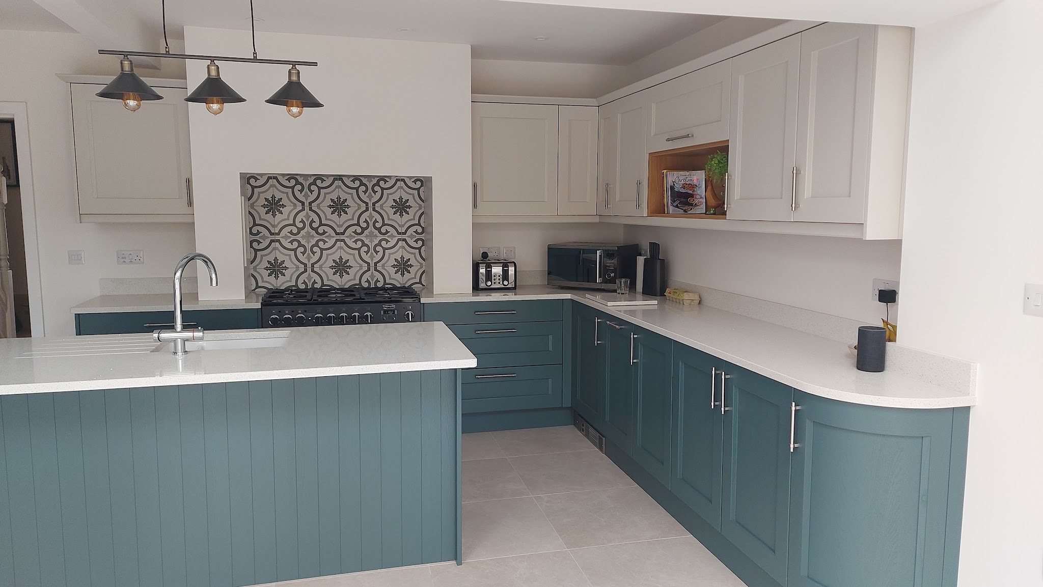 A customer's teal and white kitchen with a curved end cabinet in daylight