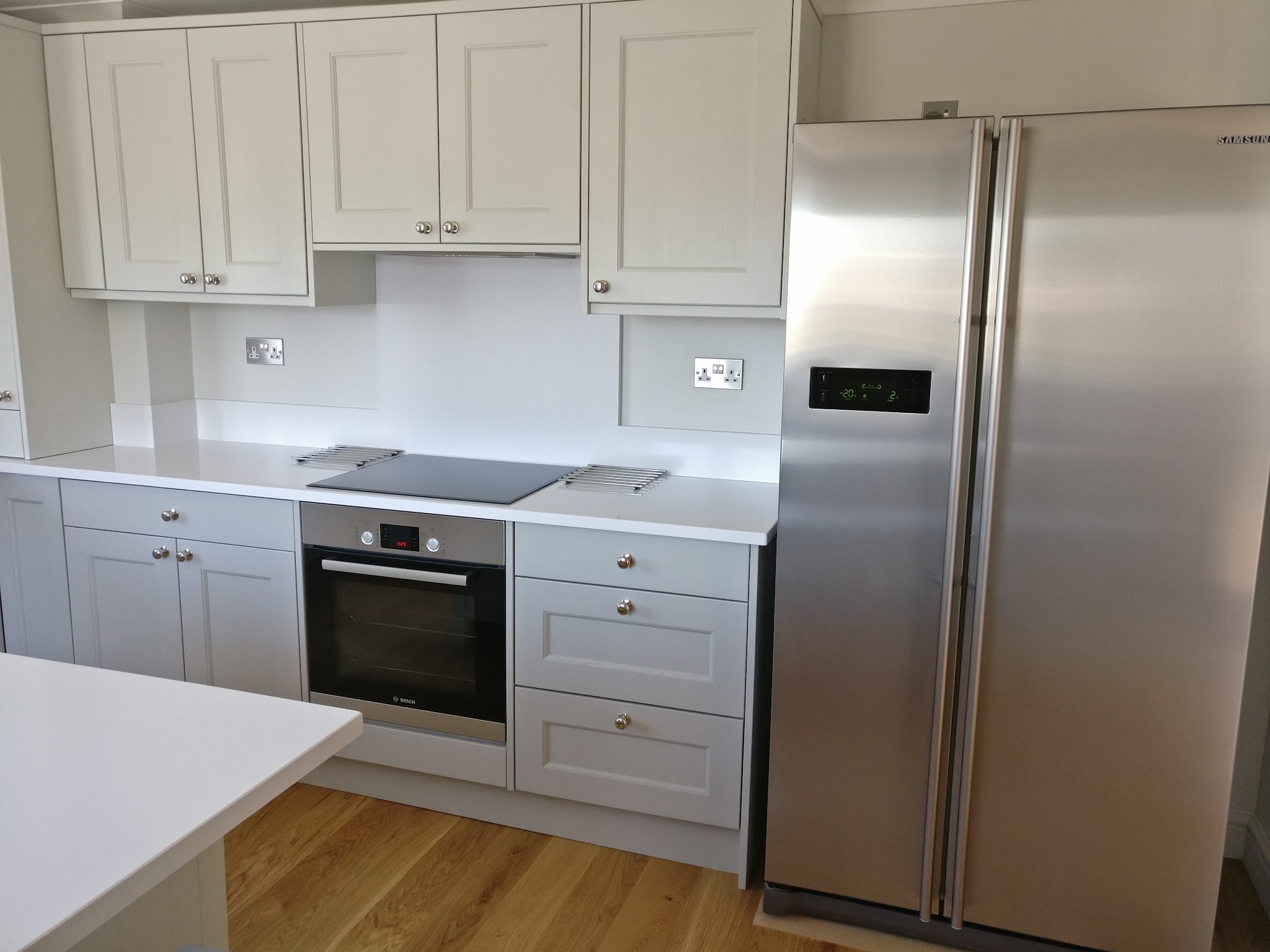 Light grey shaker kitchen with a built-in oven and a stainless American fridge freezer