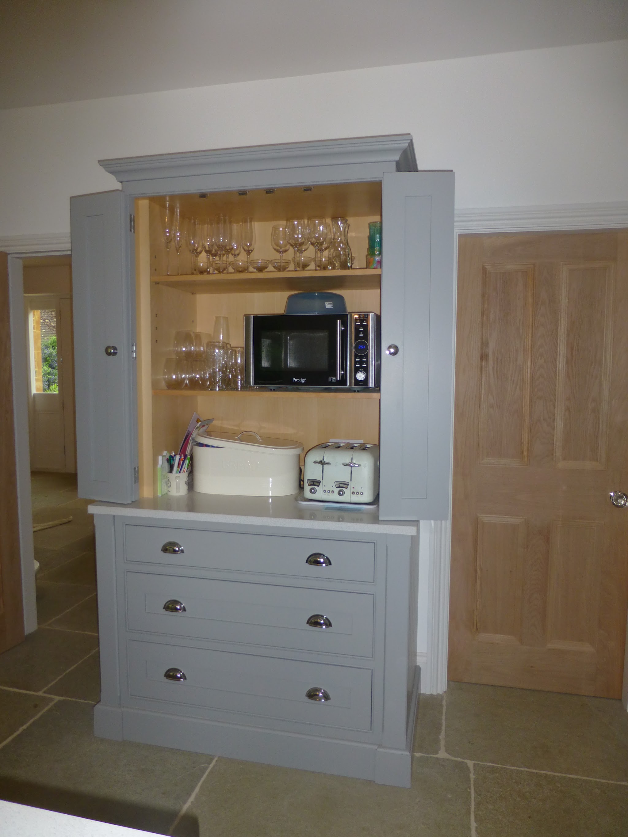 A painted larder dresser with an oak lined interior, glass shelves and drawers