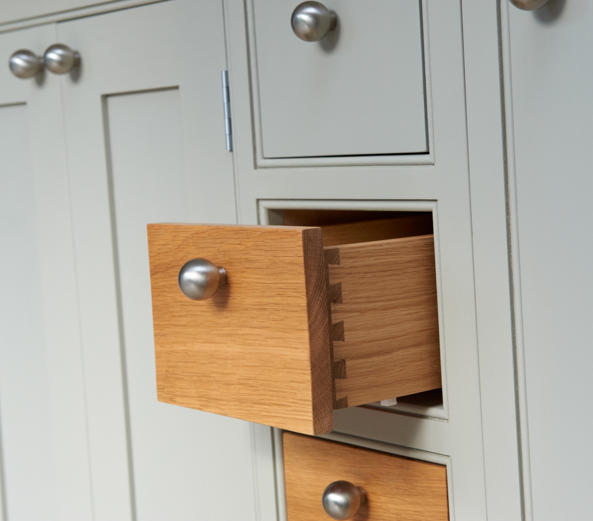 Close-up of solid oak dovetailed drawers in a painted cabinet