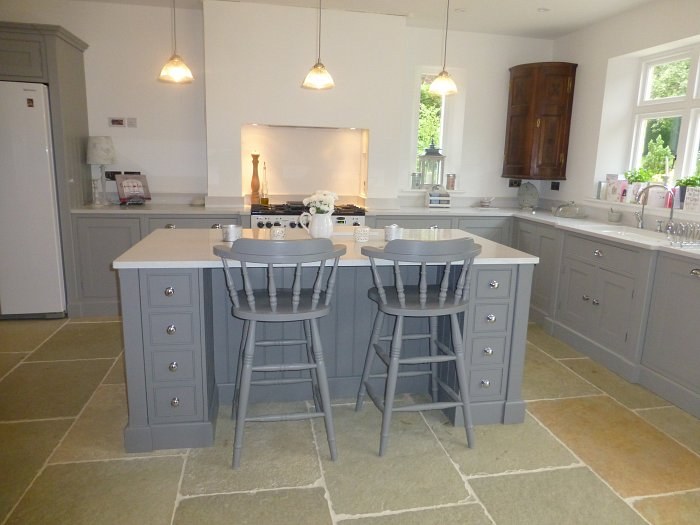 Hand-made kitchen in Bloxham with a painted island and breakfast stools on flagstones