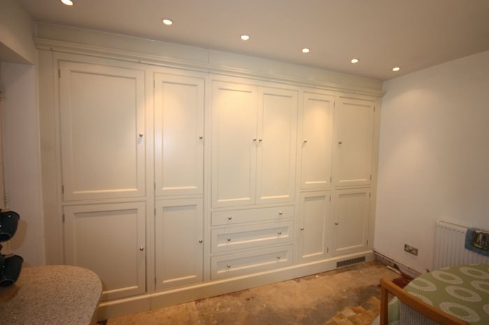 A wall of hand-made painted cabinets with panelled doors