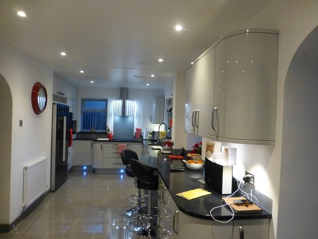 Long open kitchen in Banbury with a curved breakfast bar and arches through to the garden room