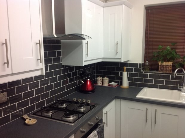 Small white gloss shaker kitchen with dark subway tiles in Banbury