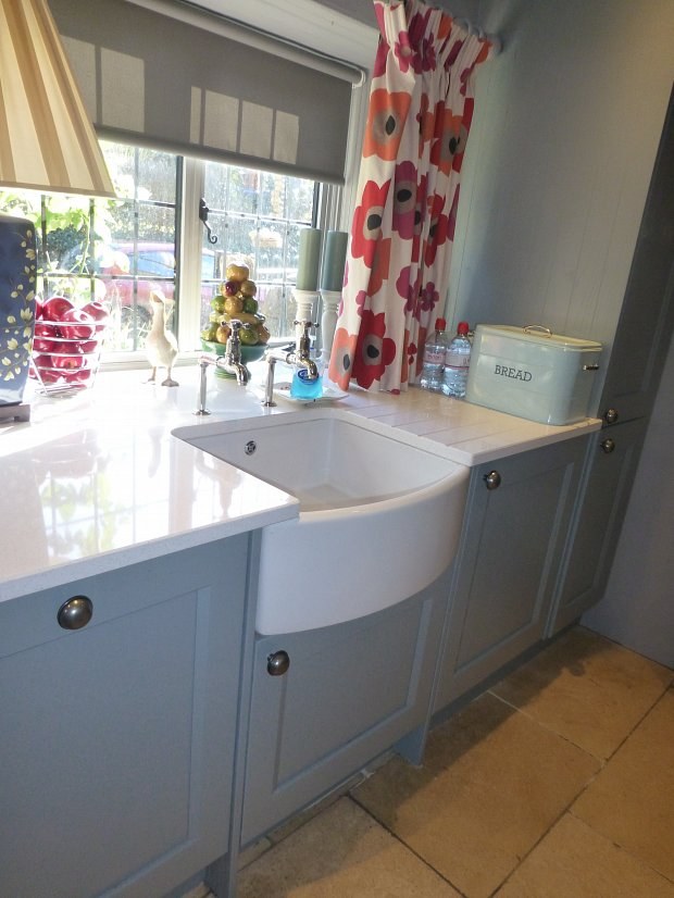 Belfast sink in grey painted cabinets beside a cottage window in Hook Norton